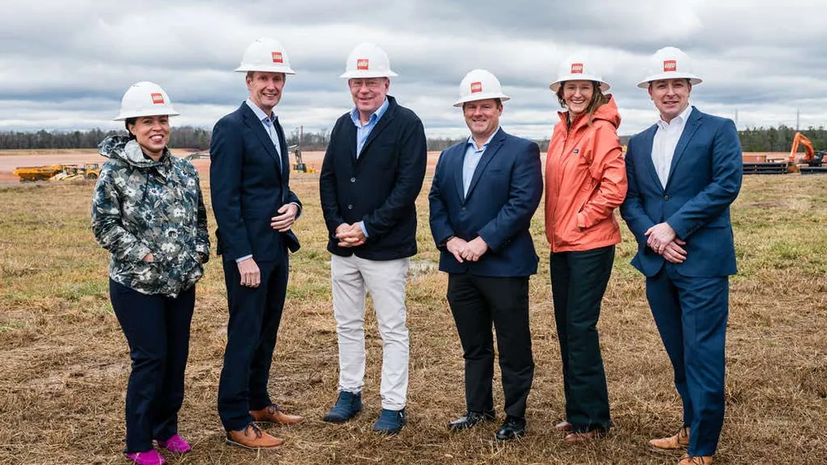 A group of people pose in hard hats.