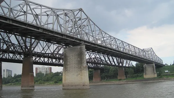 A double metal bridge spans a river.