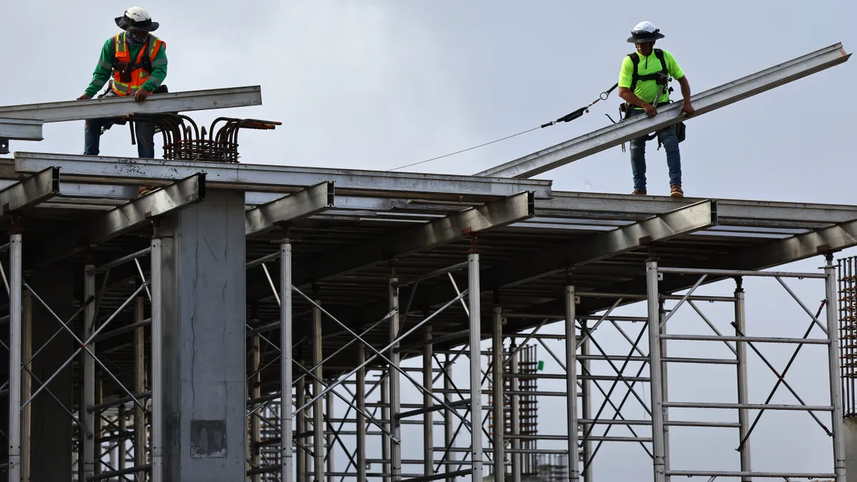 Construction workers help build a mixed-use apartment complex which will hold over 700 units of apartment housing and 95,000 square feet of commercial space on January 25, 2024 in Los Angeles