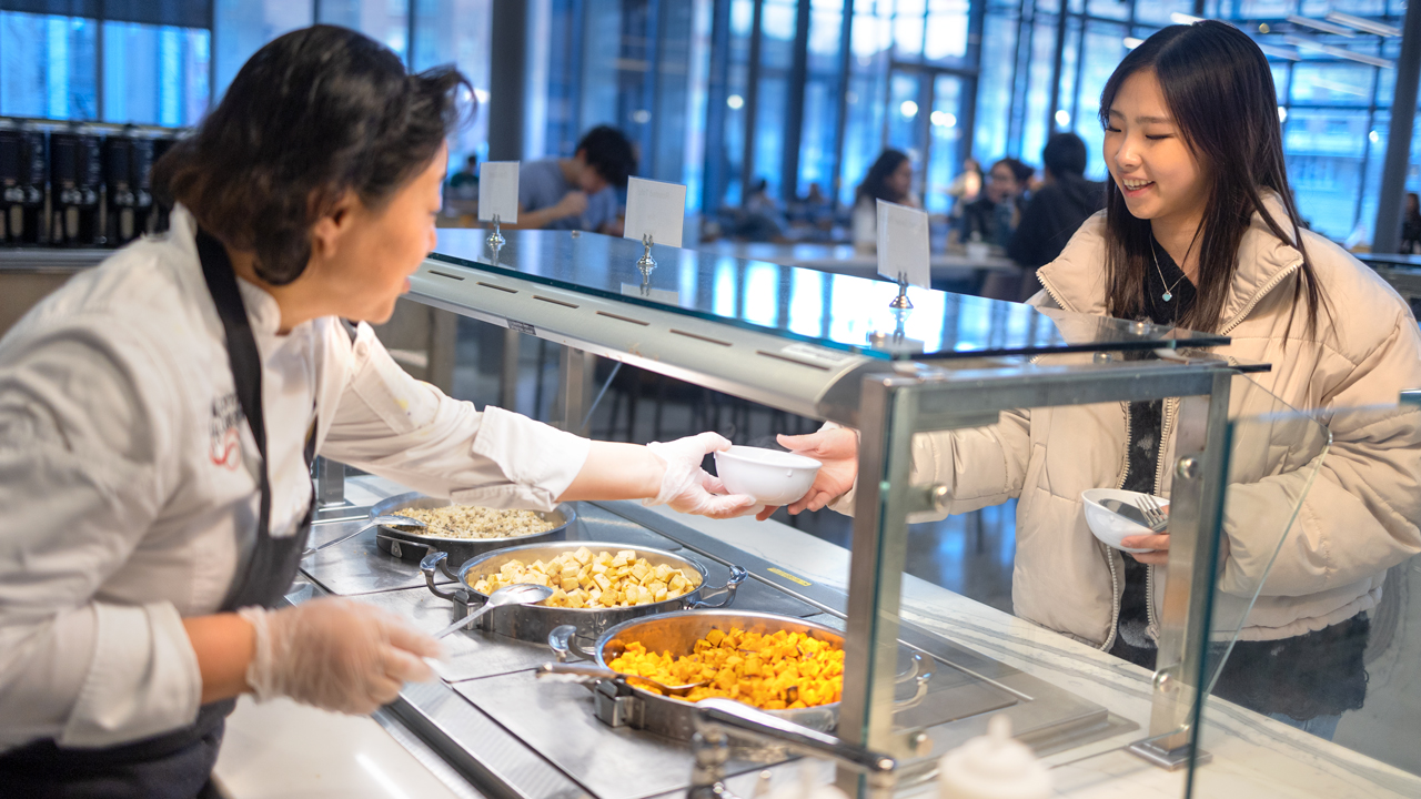 A staff member serving food in Morrison Dining Hall.