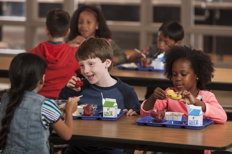 Children eating healthy foods in a school cafeteria