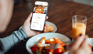 Person monitoring nutrition with smart phone.