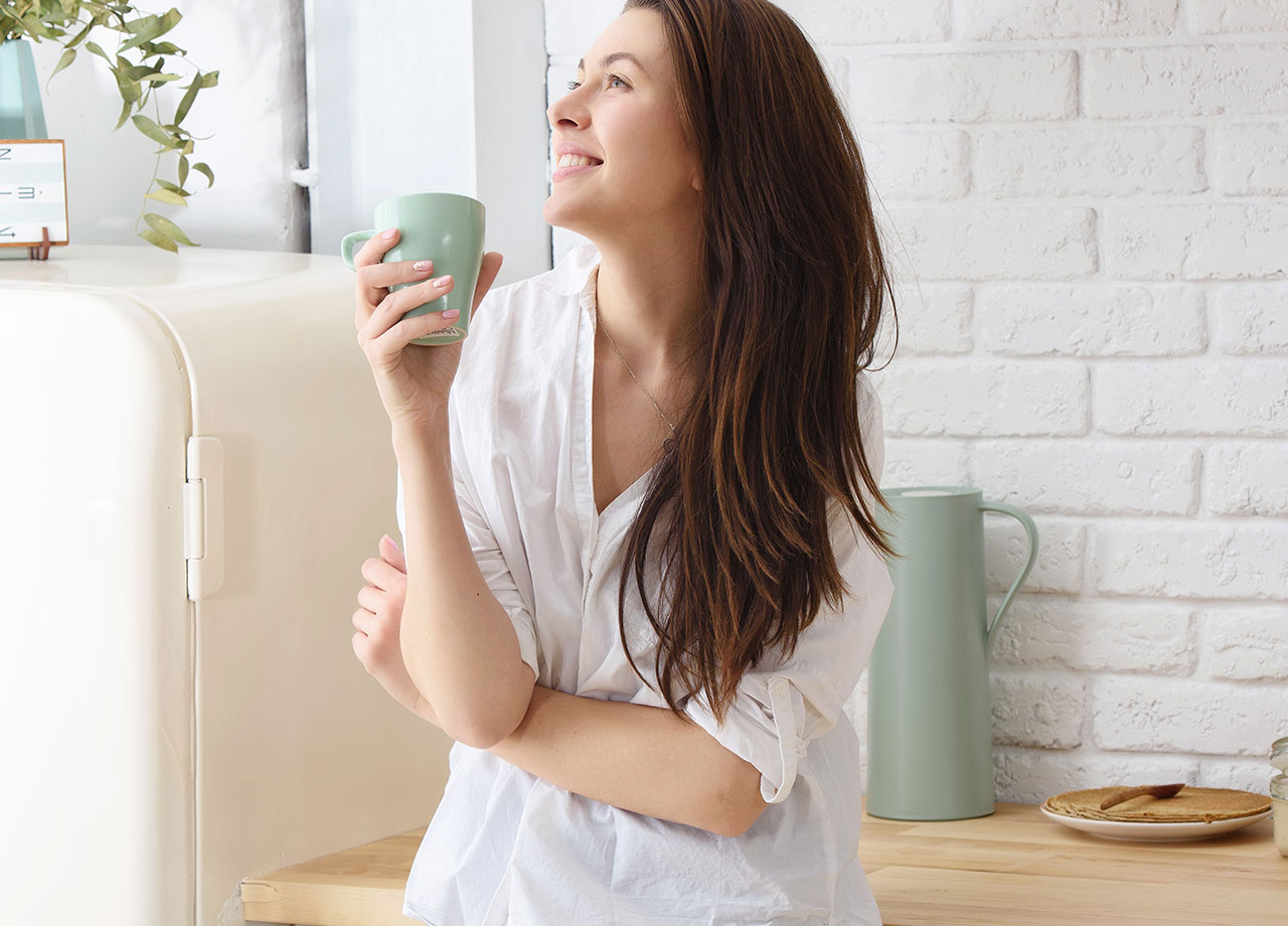 Woman smiling holding a cup