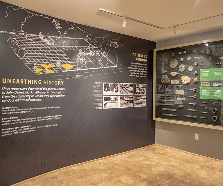 A family examining a wall of artifacts found at the site