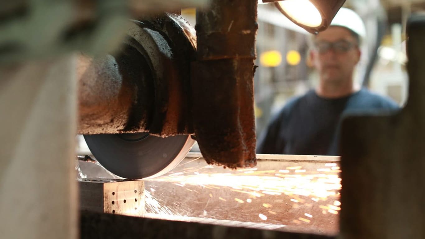 Sparks fly from a piece of metal as it is being milled