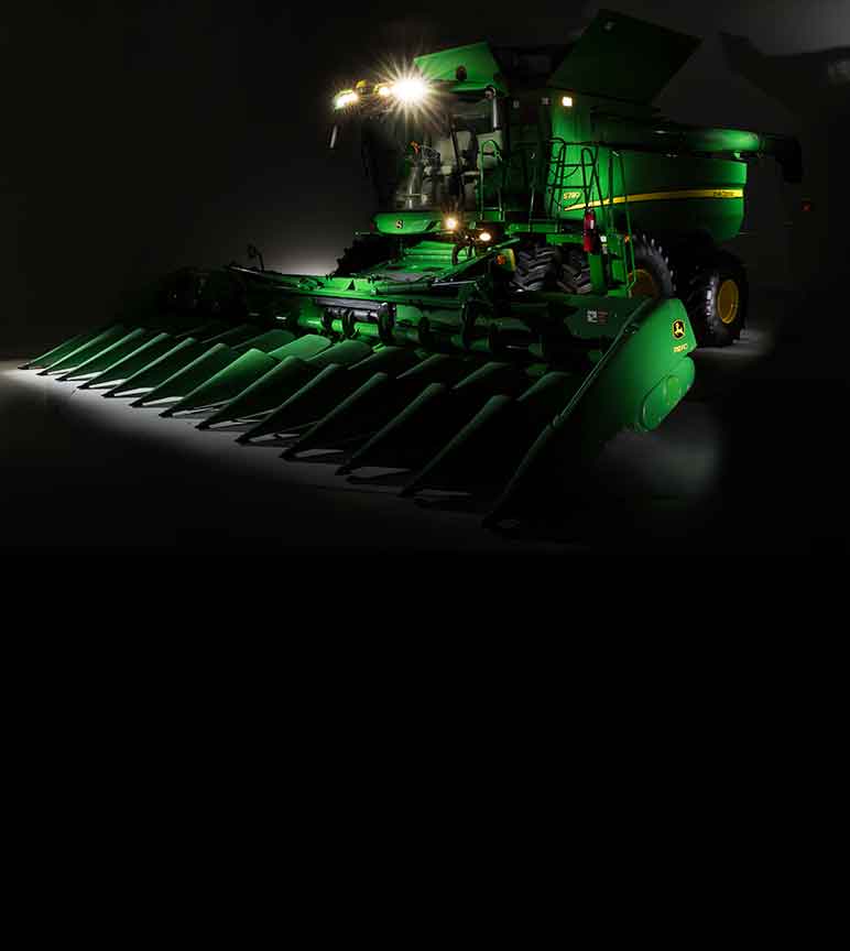 John Deere S780 Combine with lights on in a dark room