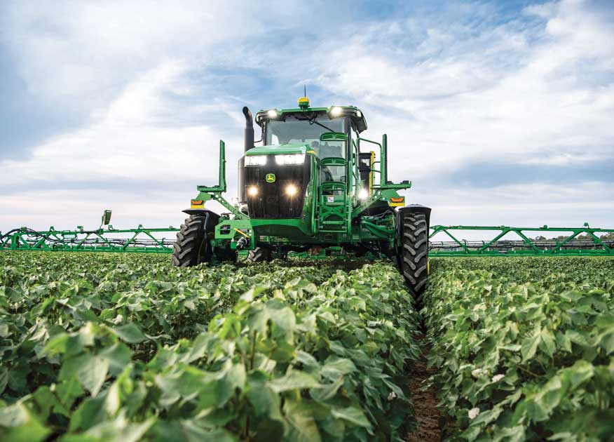 John Deere tractor with sprayer attachment operating in a field