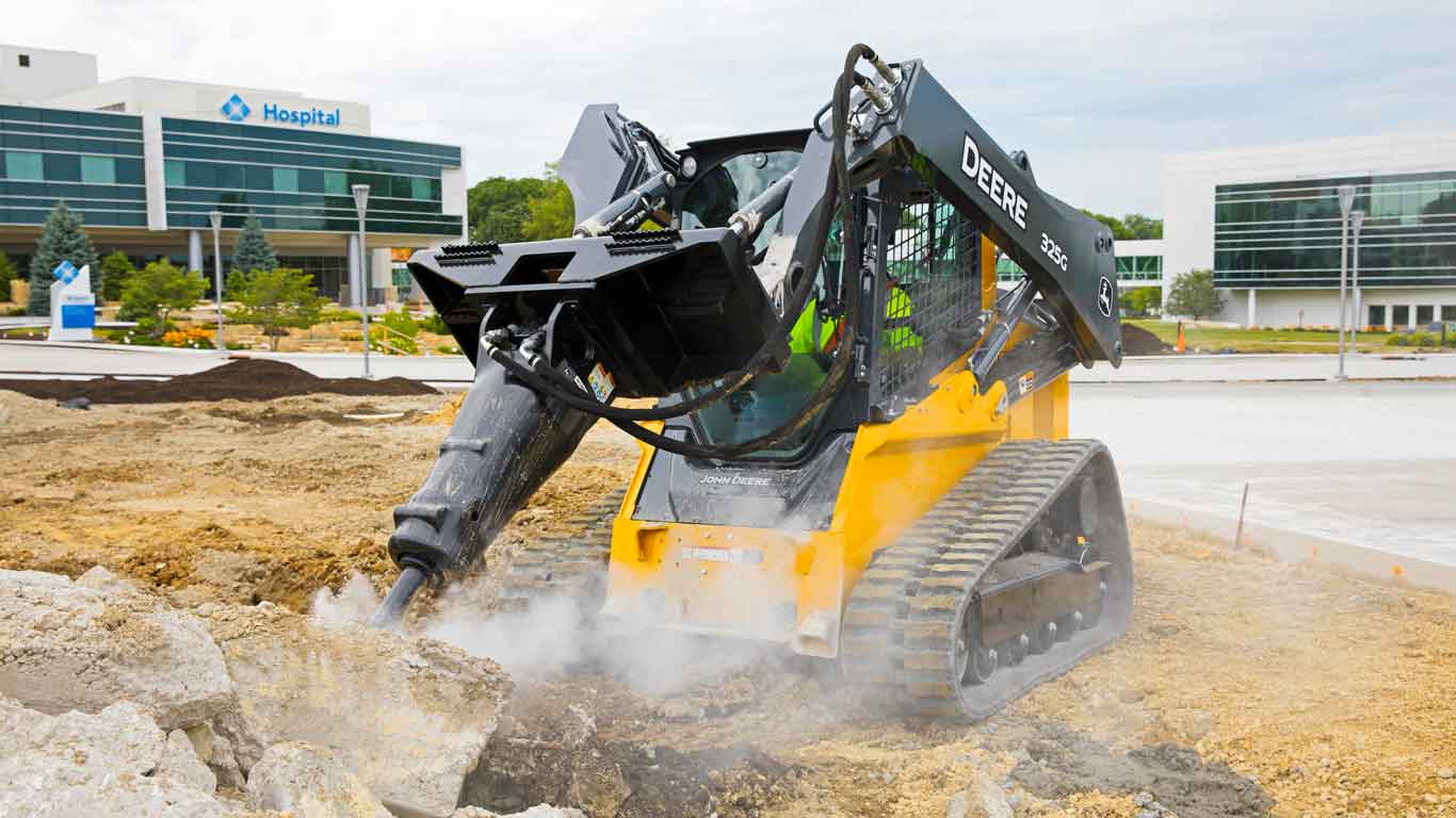 John Deere Construction equipment breaking apart concrete on a work site