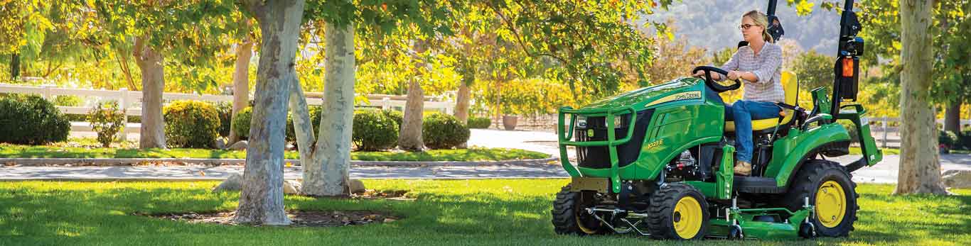 Woman operating a John Deere 1023E Compact Tractors