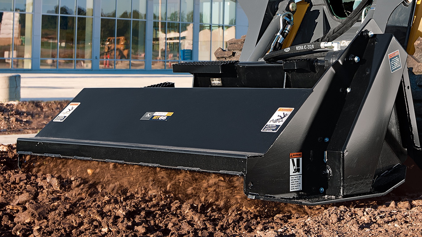 Tiller attachment on a skid steer at a commercial jobsite.