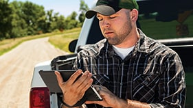 man looking at a tablet outsid