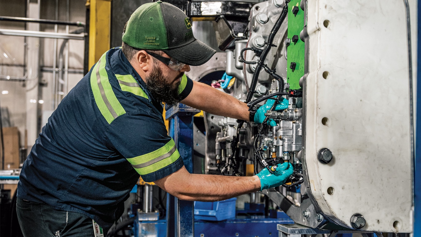 A John Deere Reman technician disassembling a transmission.