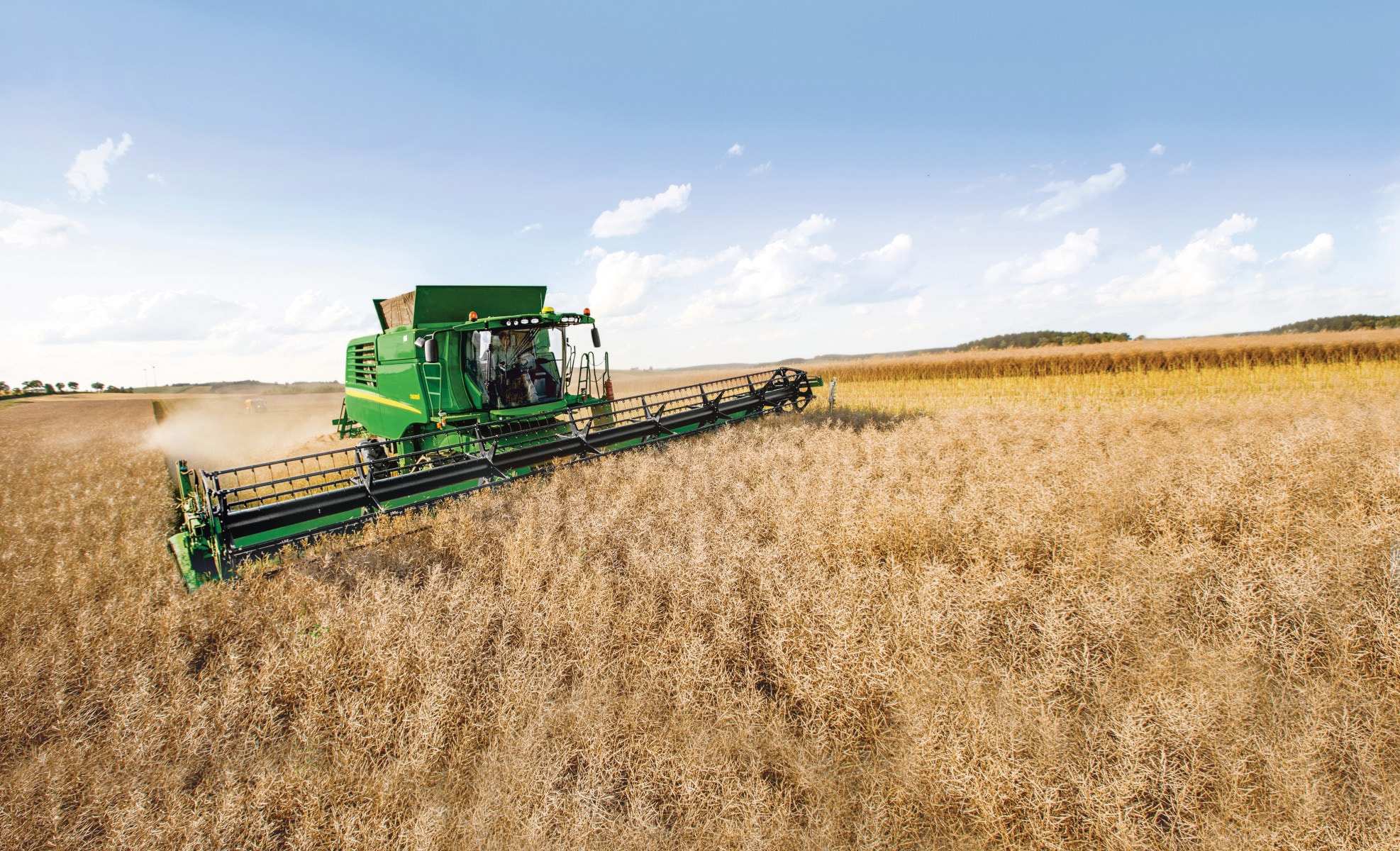 A John Deere combine harvests soybeans