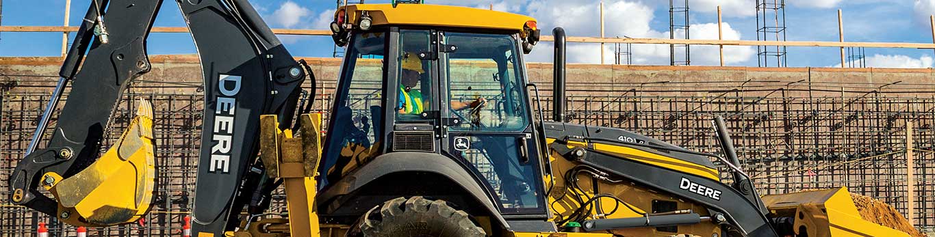 John Deere backhoe loader working on construction site.