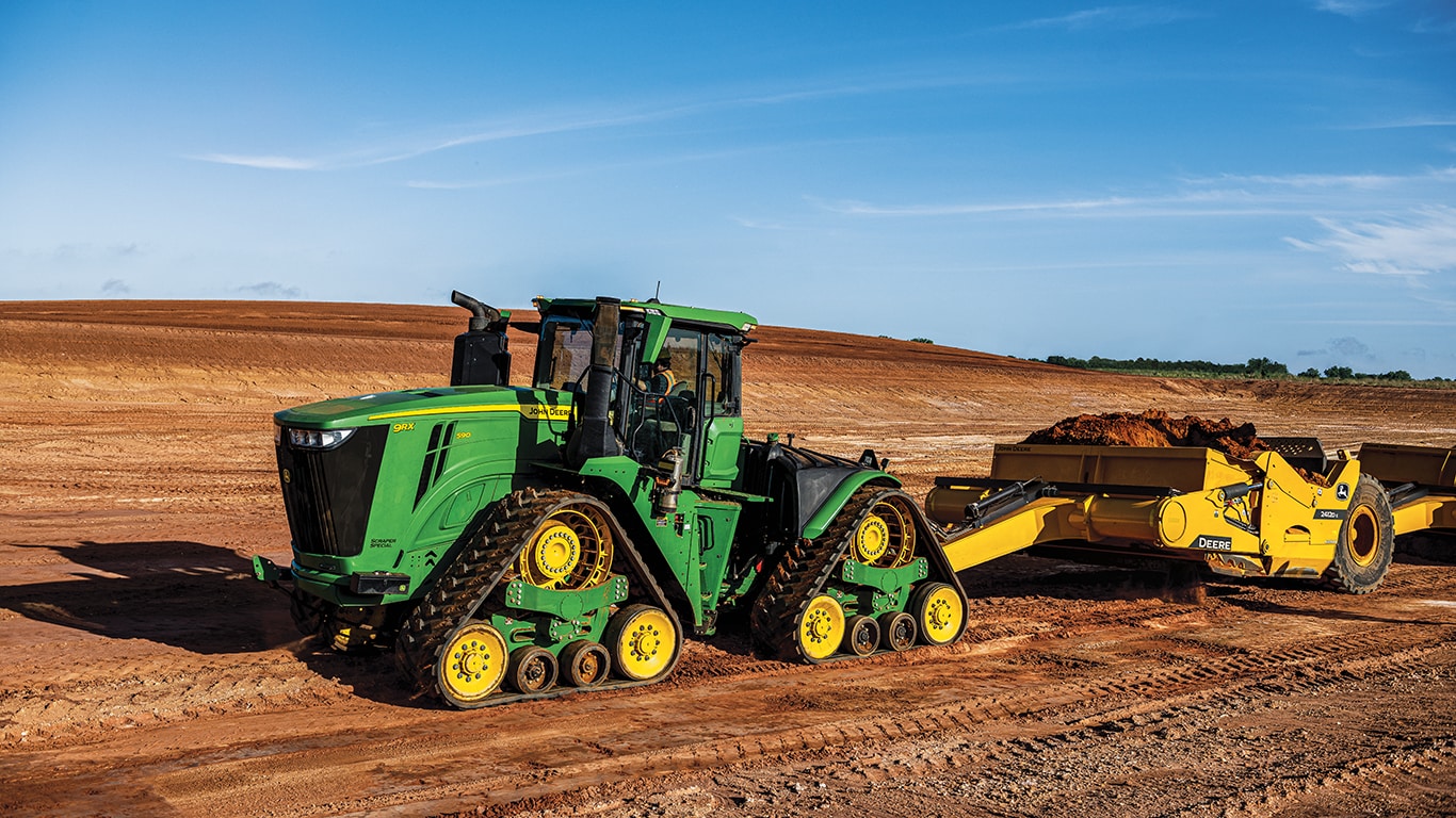 image of tractor pulling a scraper in a field