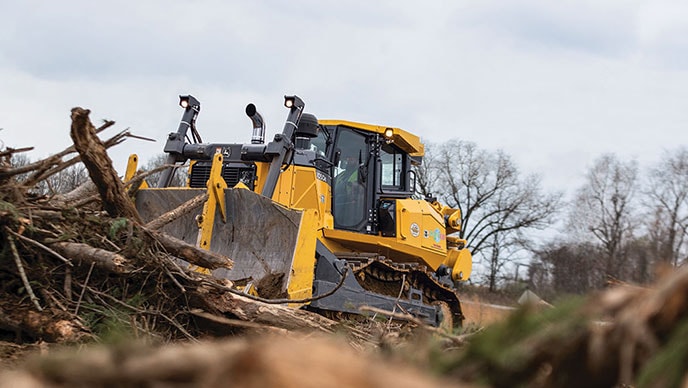 Four employees with their backs to the camera watch a John Deere 380G LC Excavator, a 460E Articulated Dump Truck, and an 872 GP SmartGrade Motor Grader work at moving dirt.