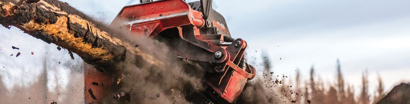 Close-up of cut logs being lifted in the air with an out of focus background.