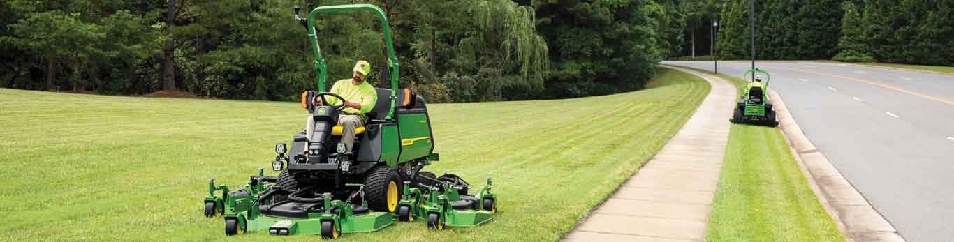 Two men operating John Deere commercial mowers