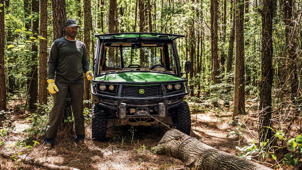 Person pulling tree trunk with XUV 845R winch