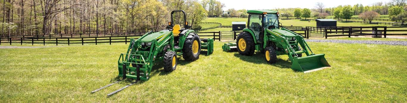 These John Deere 4066M and 4075R Compact Utility Tractors are outfitted with John Deere 440R Loaders. Implements and attachments include a Frontier AP11F Fixed Tine Pallet Fork, John Deere Materials Bucket, Frontier PR1184 Power Rake, and Frontier RT3081B Rotary Tiller.