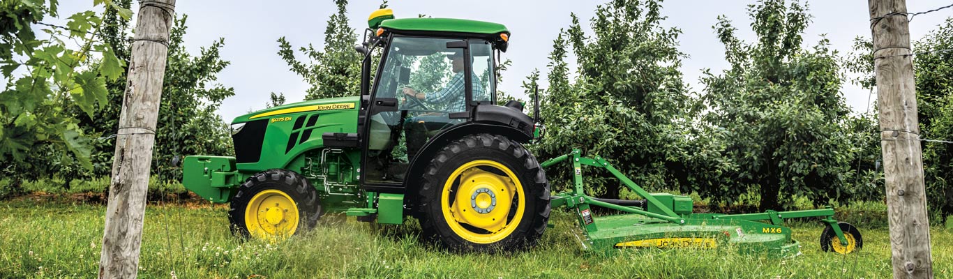 john deere tractor pulling carts in a field