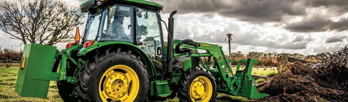 image of tractor with bucket lifting material into another truck