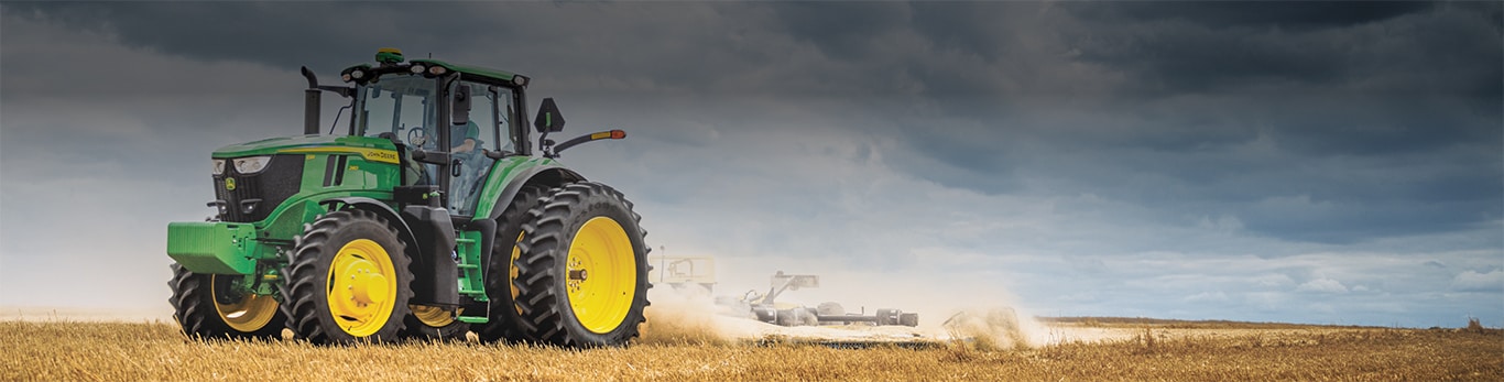 Tractor in a hay field with an overcast sky