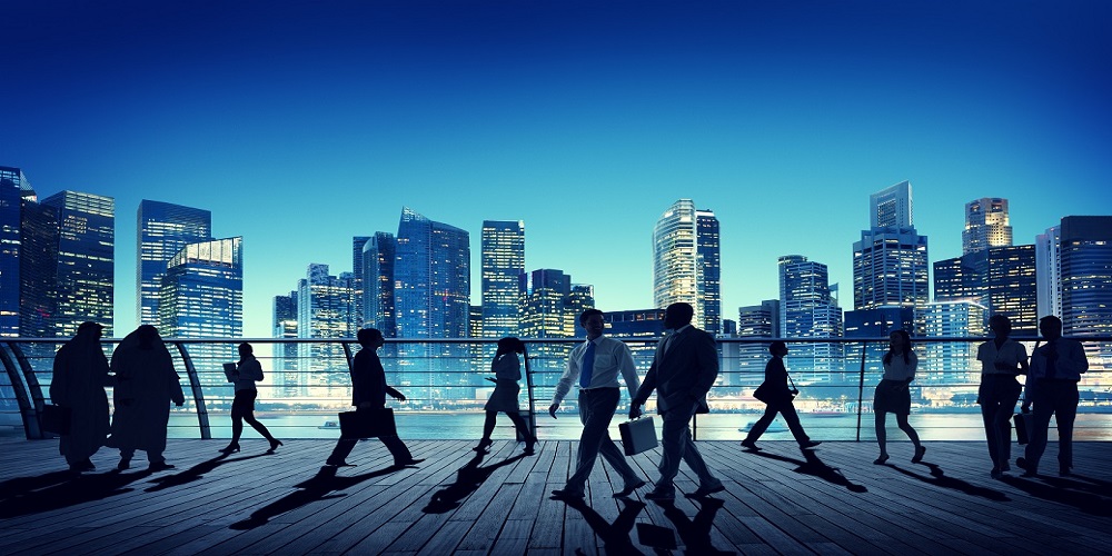 people walking on boardwalk across from city skyline