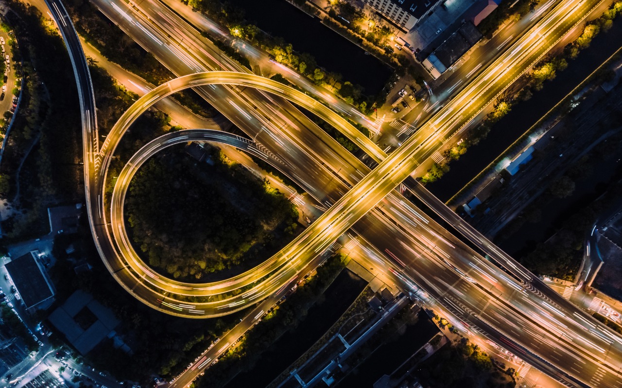 Overhead view of highway overpass, car lights visible during rush hour.