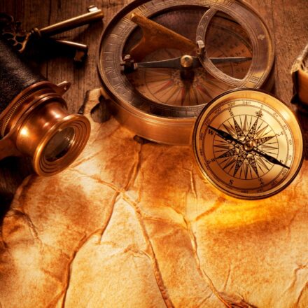 Map, binoculars, and map on an antique wooden desk.