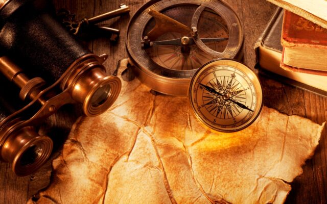 Map, binoculars, and map on an antique wooden desk.