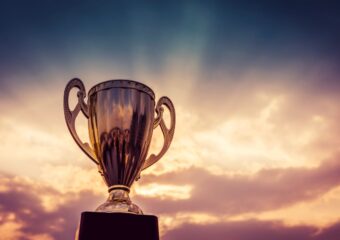 Gold trophy against a sky background.