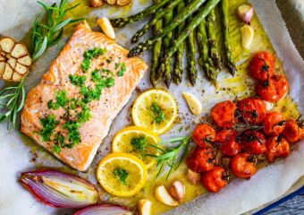 Salmon cooked with asparagus, tomatoes and other vegetables on a pan sheet.