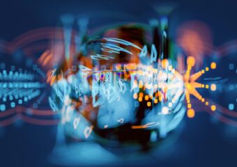 Abstract image of a sphere with light moving through it against a blurred soft blue and red background.