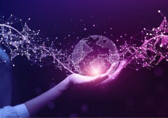 Digital image of a globe made of information code with new data moving through it, held by a woman's hand, against a purple background.