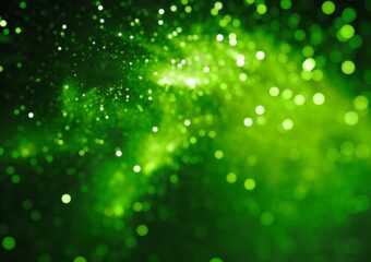 A bright green nebula cloud backlit against a black background.