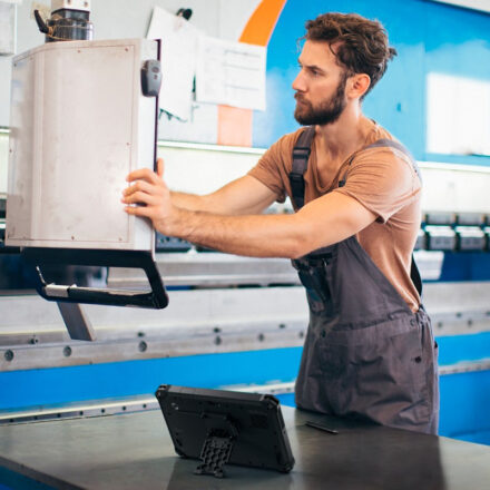 Fabrication Specialist reviewing data with Dell Latitude Rugged 7030, connected to company's infrastructure using Dell APEX Cloud Platform.