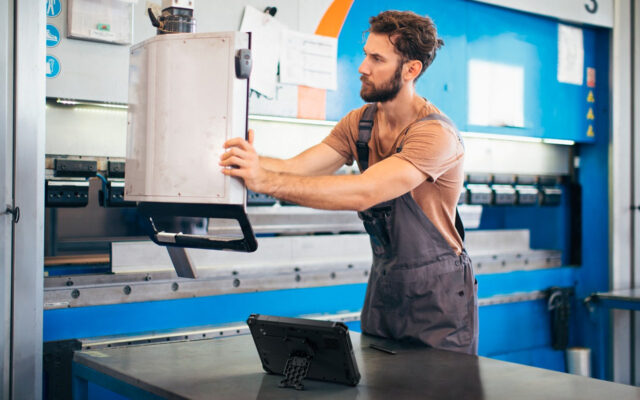 Fabrication Specialist reviewing data with Dell Latitude Rugged 7030, connected to company's infrastructure using Dell APEX Cloud Platform.