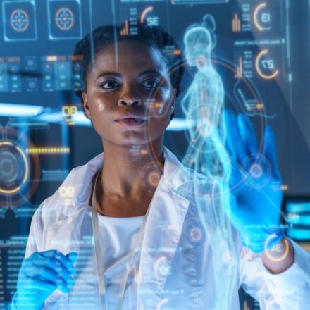 Female African-American physician analyzes patient data on state-of-the-art HUD graphics display.