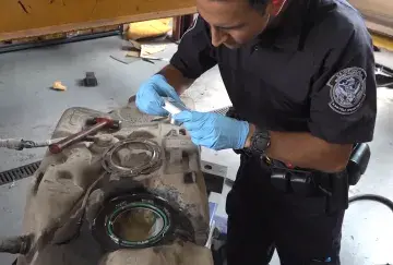 A CBP Officer Inspects a Vehicle's Gas Tak during a Secondary Inspection