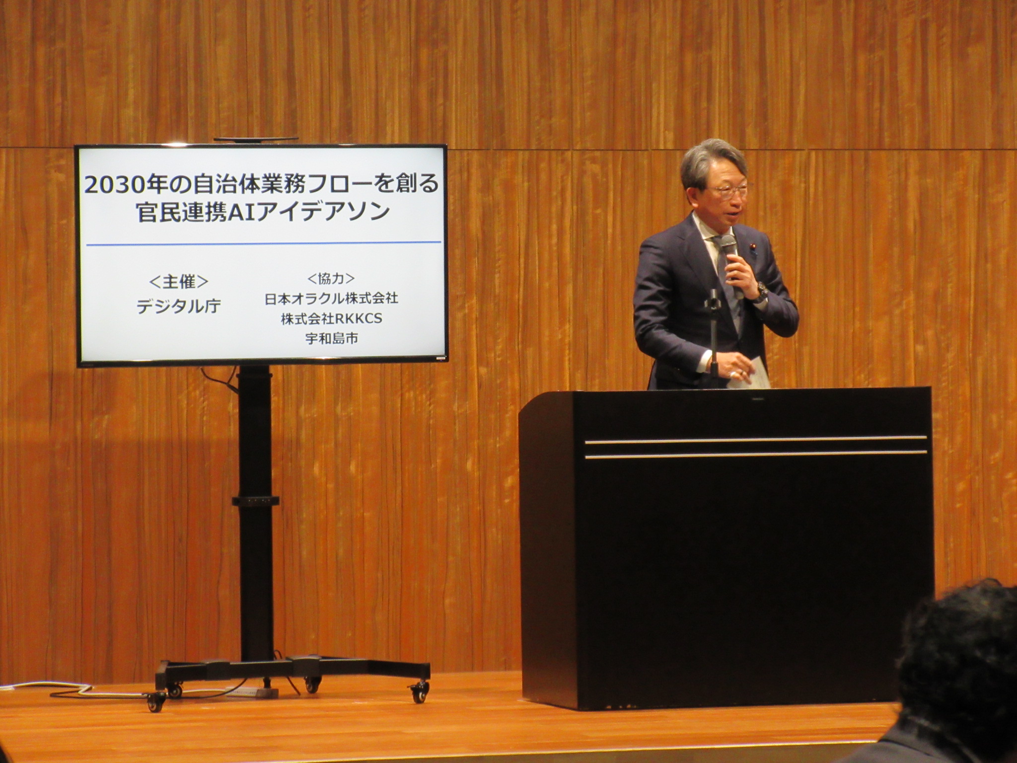 An image of a person expressing his or her expectations for Ideathon, with a monitor on the left and Mr. Taira, Minister for Digital Transformation, on the right.