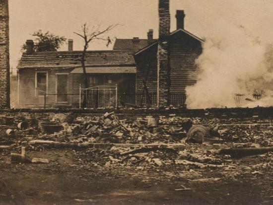 Sepia toned image of men putting out house fire