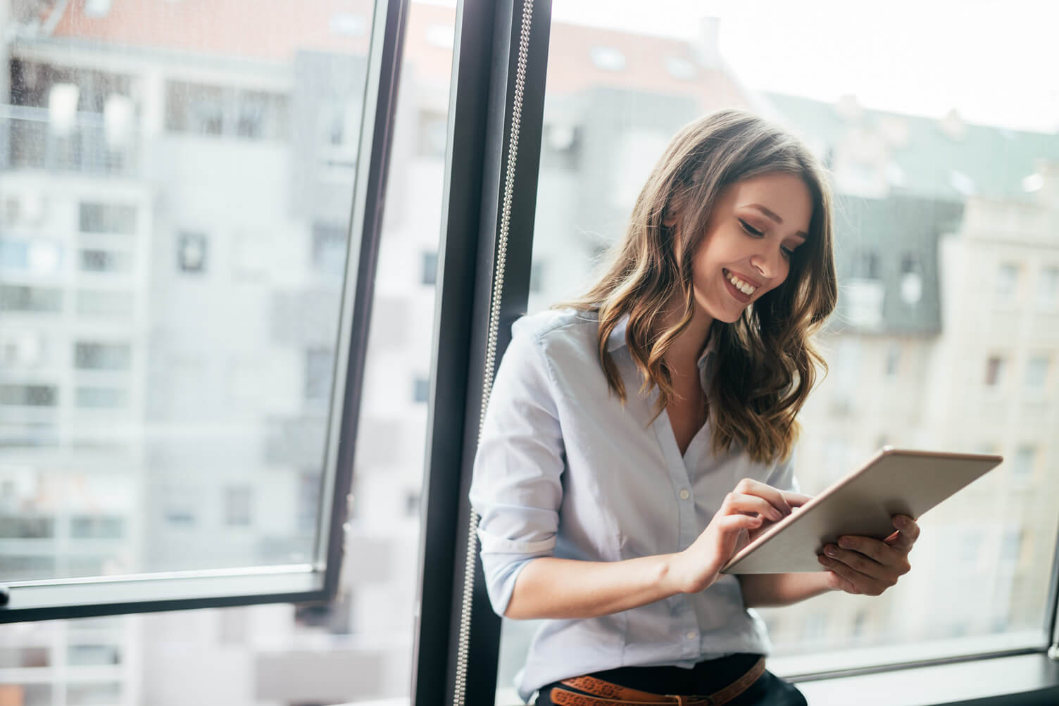 Woman Smiling Looking at Tablet Stock Photo