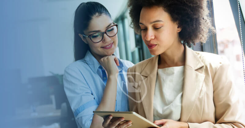 two women looking at a tablet