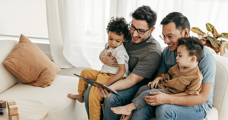 couple sitting on couch in home with children