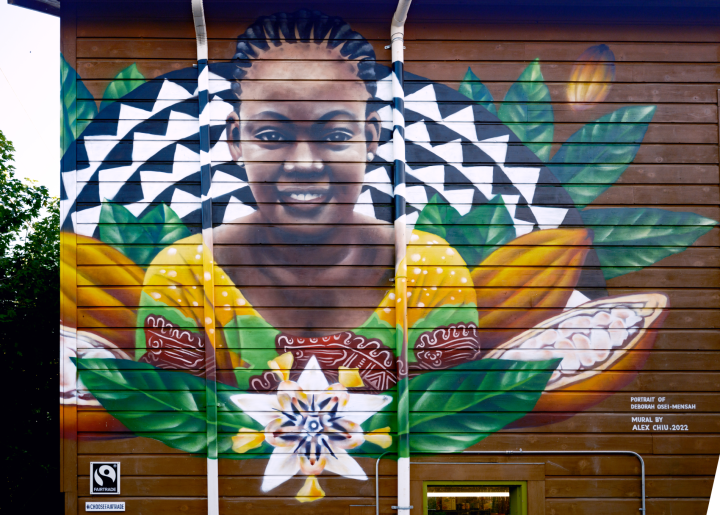 Vibrant mural of Deborah Osei-Mensah depicting cocoa pods and flowers. This mural can be found at the People's Food Co-op in Portland, Oregon.