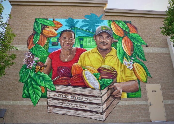 Image of mural depicting sibling cocoa farmers from Dominican Republic with cocoa pods.