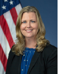 Allison Rusnak the director of FHWA’s Policy and Governmental Affairs posing for a picture in front of the American flag.