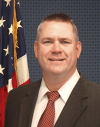 photo of the HPPI director in front of the US flag