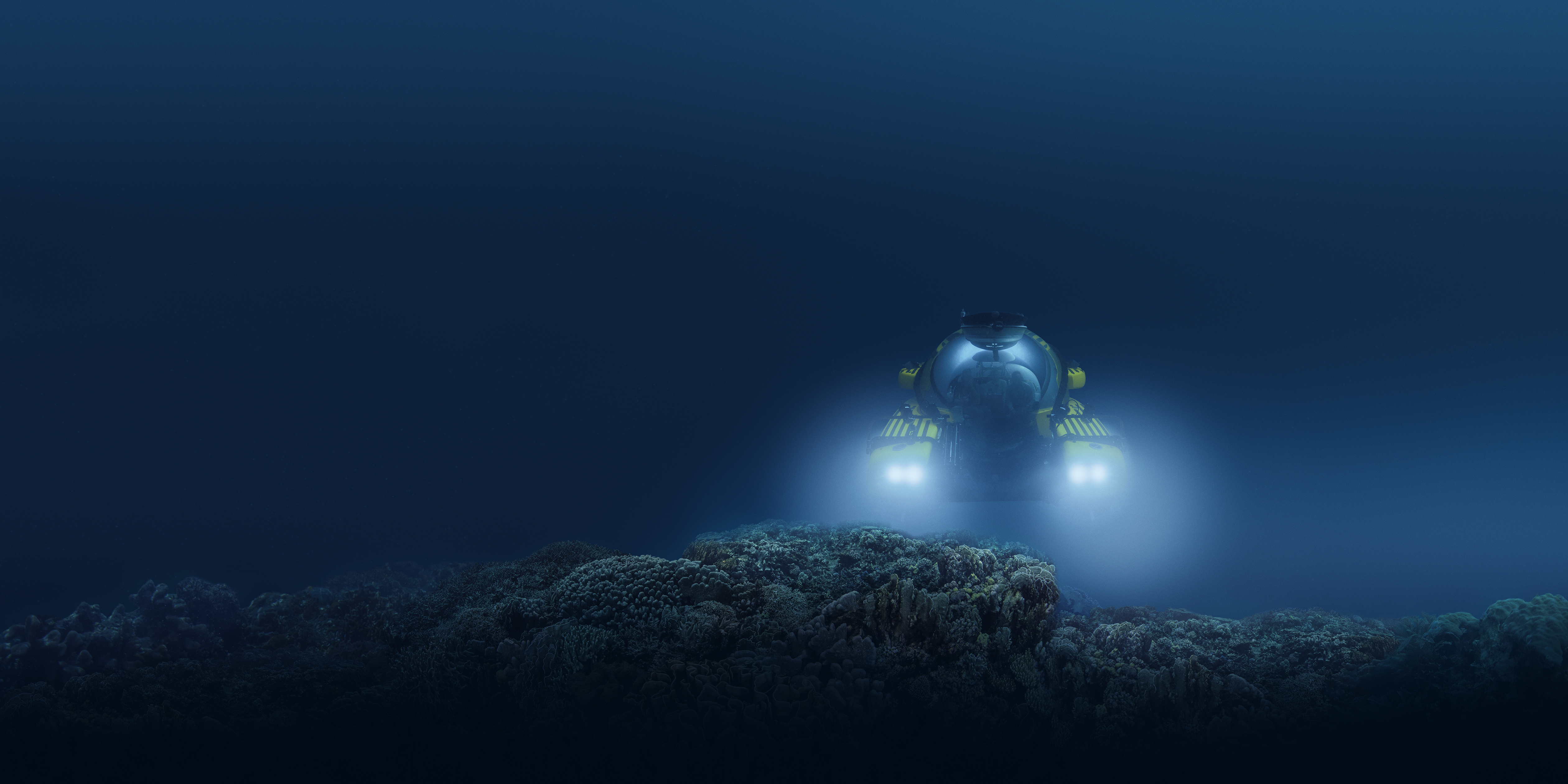 An underwater image of a submersible with its headlights illuminating a rock formation.